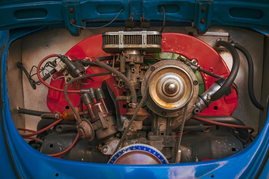 Detailed view of a vintage car engine, showcasing mechanical components and colorful housing.